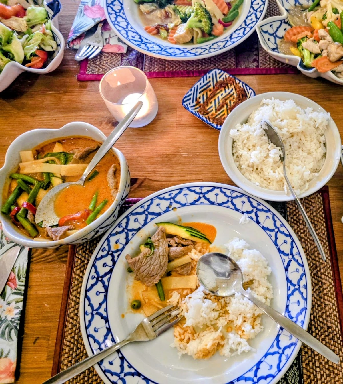 Een gedekte tafel vol gedeelde Thaise gerechten bij Kwan kookt Thais